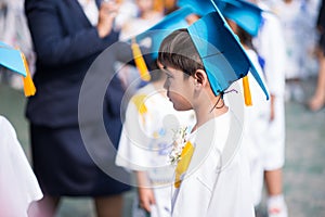 Little boy showing graduated hat uniform at kindergarten school