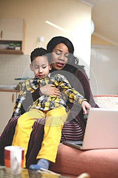 Little boy showing something to his mother on laptop.