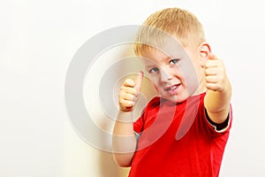 Little boy showing thumb up success hand sign gesture.