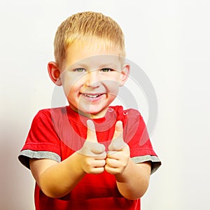 Little boy showing thumb up success hand sign gesture.