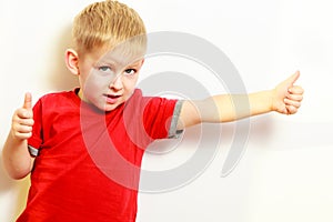 Little boy showing thumb up success hand sign gesture.