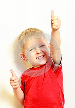 Little boy showing thumb up success hand sign gesture.