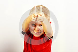 Little boy showing thumb up success hand sign gesture.