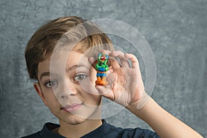 Little boy shows off his plasticine crafts