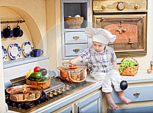 Little boy sits on a kitchen table