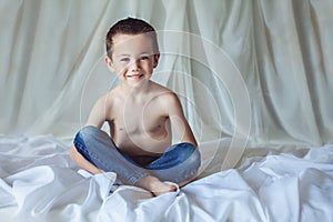 Little boy sitting on bed