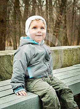 Little boy sitting on a bench