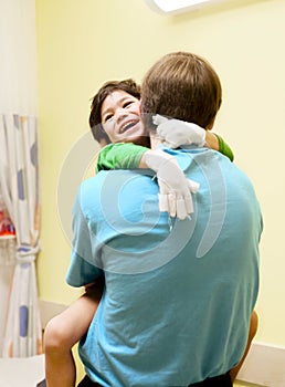 Little boy sitting in doctor's office, laughing