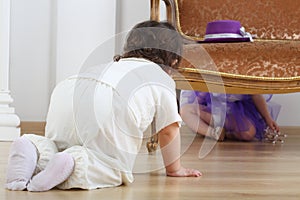 Little boy sitting on floor and looks at girl in