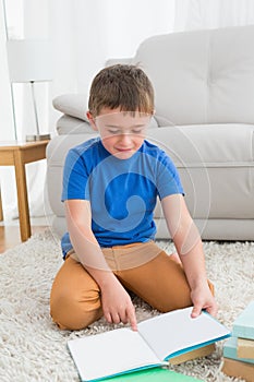 Little boy sitting on the floor reading storybook