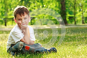 Little boy sitting on grass