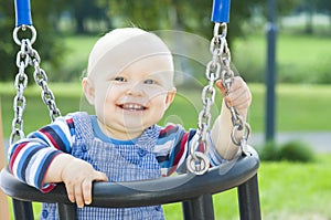 Little boy sitting on a swing