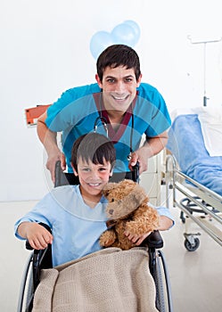 Little boy sitting on wheelchair and a doctor