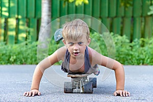 A little boy skates near a house on the road.
