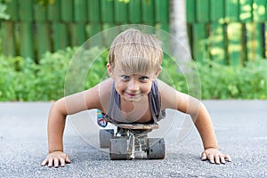 A little boy skates near a house on the road.