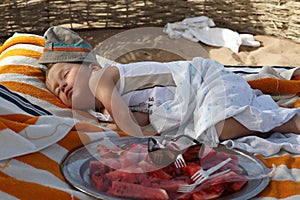 Little boy sleeping on the beach