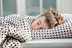 Little boy sleeping in bed