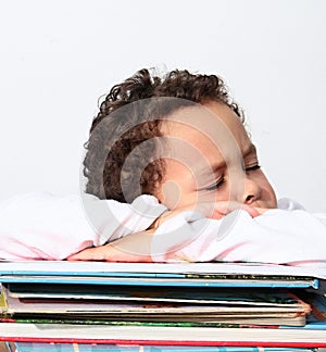 Little boy sleeping on his school books