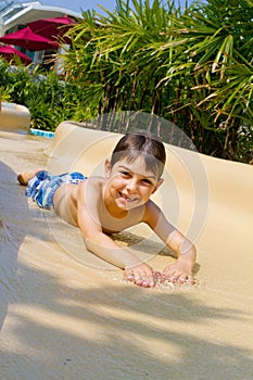 Little boy sliding down water slide