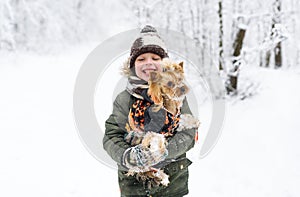 Little boy and small doggy in winter park.