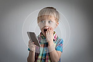 Little boy with a smartphone in his hands. childs portrait