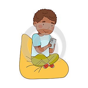 Little Boy with Smartphone Sitting on Beanbag and Playing Vector Illustration