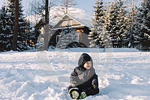 little boy in blue jacket play with snow, winter holidays