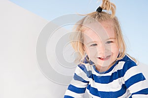 Little boy smile in navy clothes. Happy child enjoy sunny day. Kid smiling with blond hair ponytail. Kids fashion and style. Summe