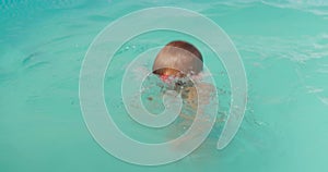 Little boy with snorkel mask plays and learns to dive and swim in the pool