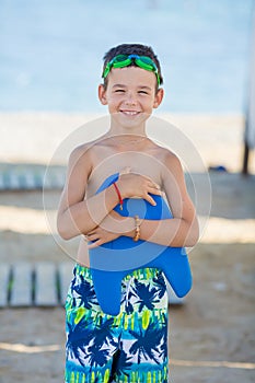 Little boy with snorkel by the sea. Cute little kid wearing mask and flippers for diving at sand tropical beach. Ocean coast