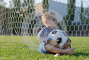 Little boy with a soccer ball on his lap