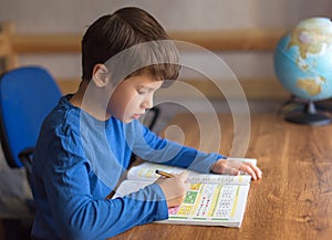 Little boy solving mathematics exercise homework