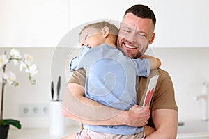 Little boy son giving dad greeting postcard with drawn red heart on Fathers Day