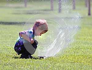 Little boy and sprinkler