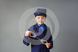 The little boy stand in a police costume and saluted photo