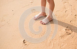 Little boy standing on the beach sand