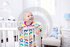 Little boy standing in bed