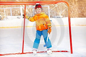 Little boy standing with hockey stick smiling