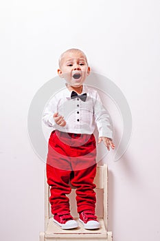 Little boy stands at the chair and tells a poem