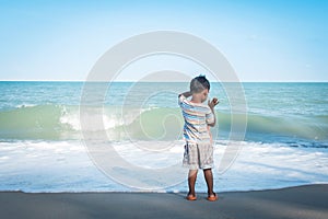 Little boy stanging looking the sea photo