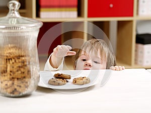 Little boy stealing cookies photo