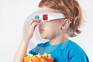 Little boy in stereo glasses with bowl of popcorn