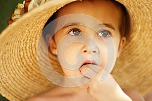 Little boy in straw hat eats