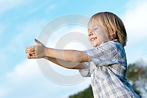 Little boy with stretched hands to sky