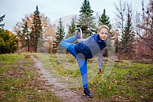 Little boy stretches his body in the forest