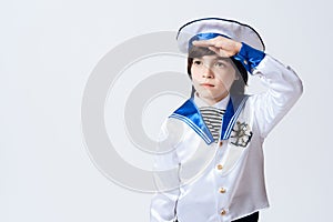 A little boy in the suit of a sailor. The dark-haired boy in the suit saluted. photo