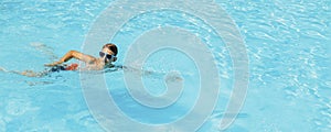 Little boy in sunglasses swimming in the pool having fun, Happy child playing in the pool, Summer vacation concept, Top portrait