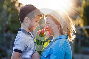 Little boy surprising mom with tulips