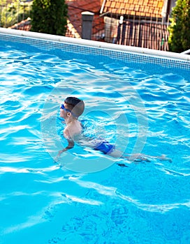 Little boy swim breaststroke in swimming pool