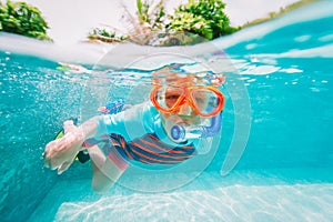 Little boy swim underwater with mask in tropical resort